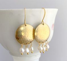 Beautiful Freshwater pearls dangle from hand brushed, hammered and domed brass circles. Ear wires are French hook style in gold plate. These earrings measure 2 inches from top of ear wire to bottom of beads. Would you like a different color to coordinate with your wardrobe? I have an extensive bead collection to accommodate most requests. Need more? Please message me for pricing. Your earrings will arrive in a lovely gift box with a ribbon, ready for gift-giving. Please see my shop policies on t Single Dangle Brass Pearl Earring, Brass Dangle Chandelier Earrings With Pearl Drop, Brass Pearl Drop Dangle Chandelier Earrings, Brass Chandelier Earrings With Pearl Drop, Dangle Brass Pearl Earrings, Brass Dangle Pearl Earrings For Pierced Ears, Dangle Pearl Earrings With Brass, Pierced Brass Dangle Pearl Earrings, Pierced Dangle Pearl Earrings In Brass