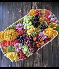 a platter filled with fruit and veggies on top of a wooden table