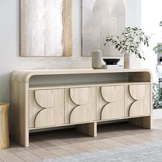 a living room scene with focus on the sideboard and plant in the vases