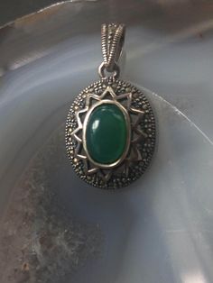 Beautiful green jade pendant in sterling silver. This vintage pendant features an antique style design with en cabachon cut green jade in bezel setting placed in the middle. It would make a lovely addition to every jewelry collection. Length: 3 cm The item remains in very good vintage condition.  Hallmarked for sterling silver. For your own impression, review the pictures pictures carefully prior to making a purchase. Any wear is part of character. Matching earrings available. https://koorboutiq Vintage Jade Round Pendant Jewelry, Silver Jade Oval Pendant Jewelry, Antique Green Oval Jewelry, Green Pendant Jewelry With Stone Setting, Antique Green Round Pendant Jewelry, Green Stone Setting Pendant Jewelry, Green Sterling Silver Medallion Jewelry, Vintage Jade Gemstone Jewelry, Vintage Jewelry Pendant With Stone Setting