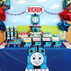 a thomas the train birthday party with balloons and streamers on the wall, table