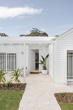 a white house with a walkway leading to the front door