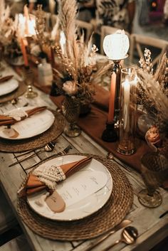 a table set with place settings and candles