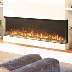 a living room with a couch and a fire place in the wall that is lit