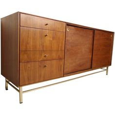 a large wooden cabinet with four drawers on one side and two metal legs on the other