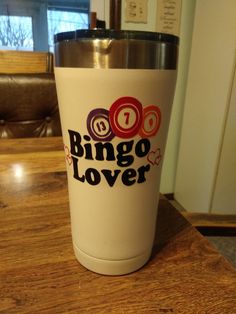 a white coffee cup sitting on top of a wooden table