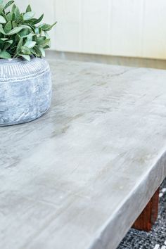 a concrete table with a potted plant on top