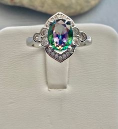 a ring with an amethorate surrounded by white diamonds on top of a box