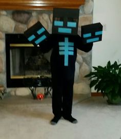 a man in a minecraft costume standing in front of a fire place holding two blocks