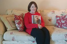 a woman sitting on a couch holding a book