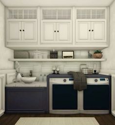 a kitchen with white cabinets and black appliances on the counter top, along with a rug in front of it