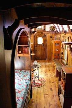 the inside of a tiny house with wood floors and walls, along with a bed