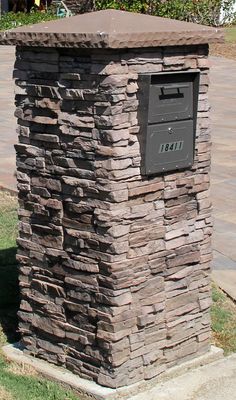 a stone mailbox sitting on the side of a road