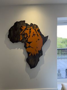 a wooden africa sign mounted to the side of a white wall next to a window