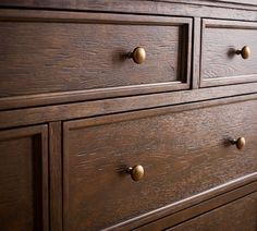 a wooden dresser with brass handles and knobs on it's drawers is shown