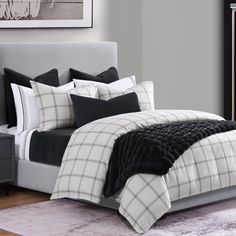 a bed with black and white comforters in a bedroom