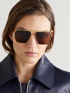 Find BOTTEGA VENETA Original Aviator-style -tone Sunglasses on Editorialist. Bottega Veneta Eyewear puts a fresh spin on so many classics and has managed to make aviator-style sunglasses even cooler with its octagon-shaped frames. This 'Original' gold-tone pair houses brown lenses with adjustable nose pads for a comfortable fit. The acetate-tipped arms are designed with the brand's signature double bars and discreetly engraved with a logo. Aviator Sunglasses Outfit, Bottega Veneta Sunglasses, Glasses Png, Sunglasses Outfit, Black Aviator Sunglasses, Gold Aviator Sunglasses, Sunglasses Women Aviators, New Bottega, New Sunglasses