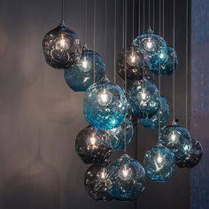 a bunch of blue glass balls hanging from a chandelier with lights on them