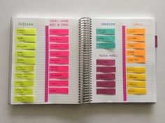 an open planner with sticky notes attached to each page and colored stickers on the pages