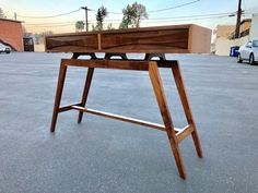 a wooden table sitting in the middle of a parking lot