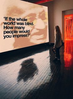 a woman standing in front of a large screen with a quote on it that reads if the whole world was blind how many people would you imppress?