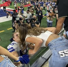 a group of people standing on top of a football field