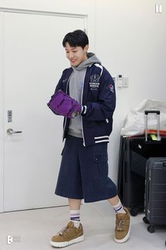 a young man holding a purple bag in his hand