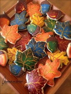 cookies decorated with autumn leaves on a wooden tray