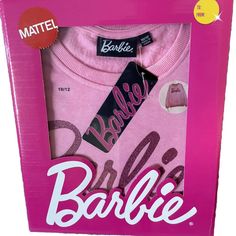 the barbie doll is in its pink box with her name on it's shirt