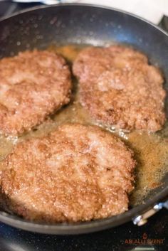 three hamburger patties cooking in a frying pan on the stove top with oil