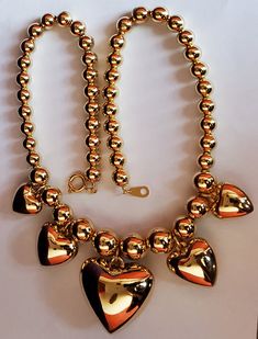 1980’s goldtone statement puff hearts necklace.Necklace measures 17"Deadstock. High quality, strung on a chain rather than a string. 80s Jewelry, Hearts Necklace, Puffed Heart, Necklace Shop, Necklace Necklace, Vintage Boutique, Gold Material, Shop Necklaces, Statement Necklace