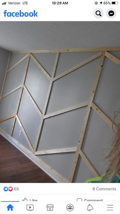 a woman is standing in front of a wall that has been constructed into a geometric pattern