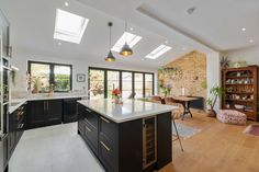 an open kitchen and dining room with skylights