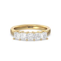 a yellow gold ring with three princess cut diamonds