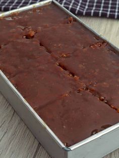 a metal pan filled with brownies on top of a wooden table