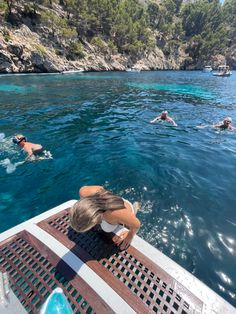 people swimming in the blue water on a boat