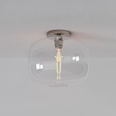 a light that is on in the ceiling with a glass dome over it and a yellow light bulb