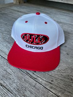 This genuine 1990s vintage adjustable Chicago Bulls snapback hat is in excellent condition! Looks like it has never been worn. It still has the cardboard headliner. Check the pics. I'd say it is medium profile. Officially Licensed by the NBA. 65% polyester, 35% cotton. Measurements: Brim: 2.75" (from end of bill to headpiece) Front: 3.00" (from base to top - not to crown) Throwback White Hat For Streetwear, Throwback White Snapback Hat, White Throwback Snapback Hat, White Retro Adjustable Fitted Hat, White Adjustable Retro Fitted Hat, Retro Snapback Hat With Curved Bill And Embroidered Logo, White Retro Trucker Hat With Curved Brim, Retro White Trucker Hat With Curved Brim, Vintage White Trucker Hat For Baseball Season