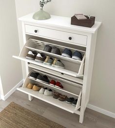 a white shoe rack with several pairs of shoes