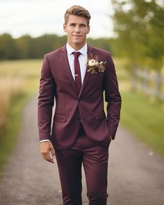 a man in a suit and tie is standing on the road with his hands in his pockets