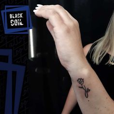 a woman with a small tattoo on her left arm and the word black cole written in it