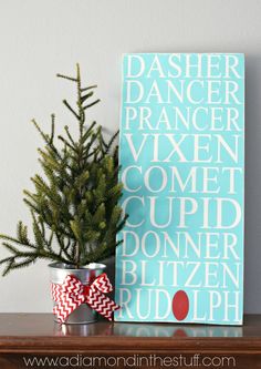 a small christmas tree sitting on top of a wooden table next to a sign that says dasher dancer