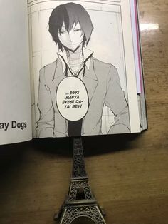 an open book with the image of a man standing in front of the eiffel tower