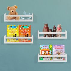 three white shelves with books and stuffed animals on them, against a blue painted wall