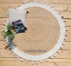 a round rug with a plant on it and a magazine laying on top of it