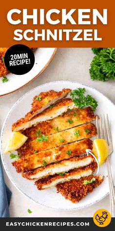 chicken schnitzel on a white plate with lemon wedges and parsley