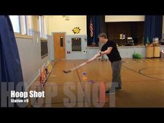 a man hitting a ball with a bat in a gym