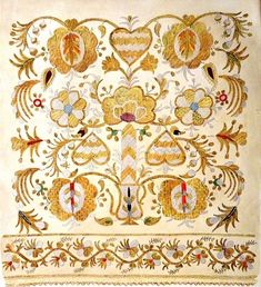 an embroidered cloth with gold and red flowers on white fabric, in the shape of a heart