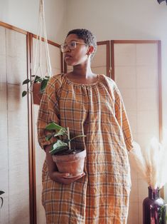 a woman holding a potted plant in her hands