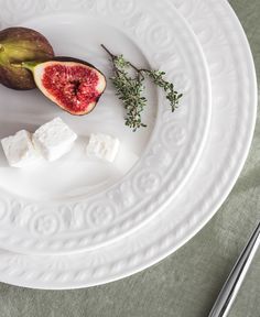 a white plate topped with figs and marshmallows next to silverware